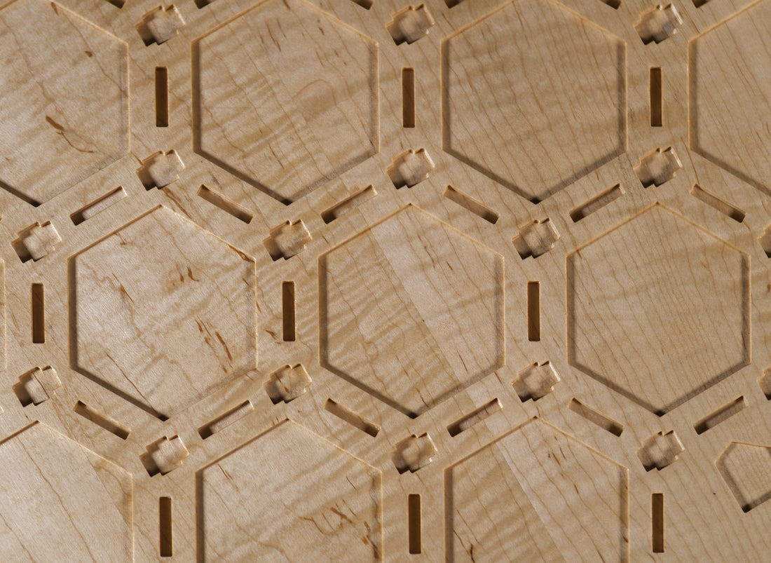 Hex-grid macro of a Murray Industries Heirloom Inlay Catan board — patent-pending precision-carved tile pockets