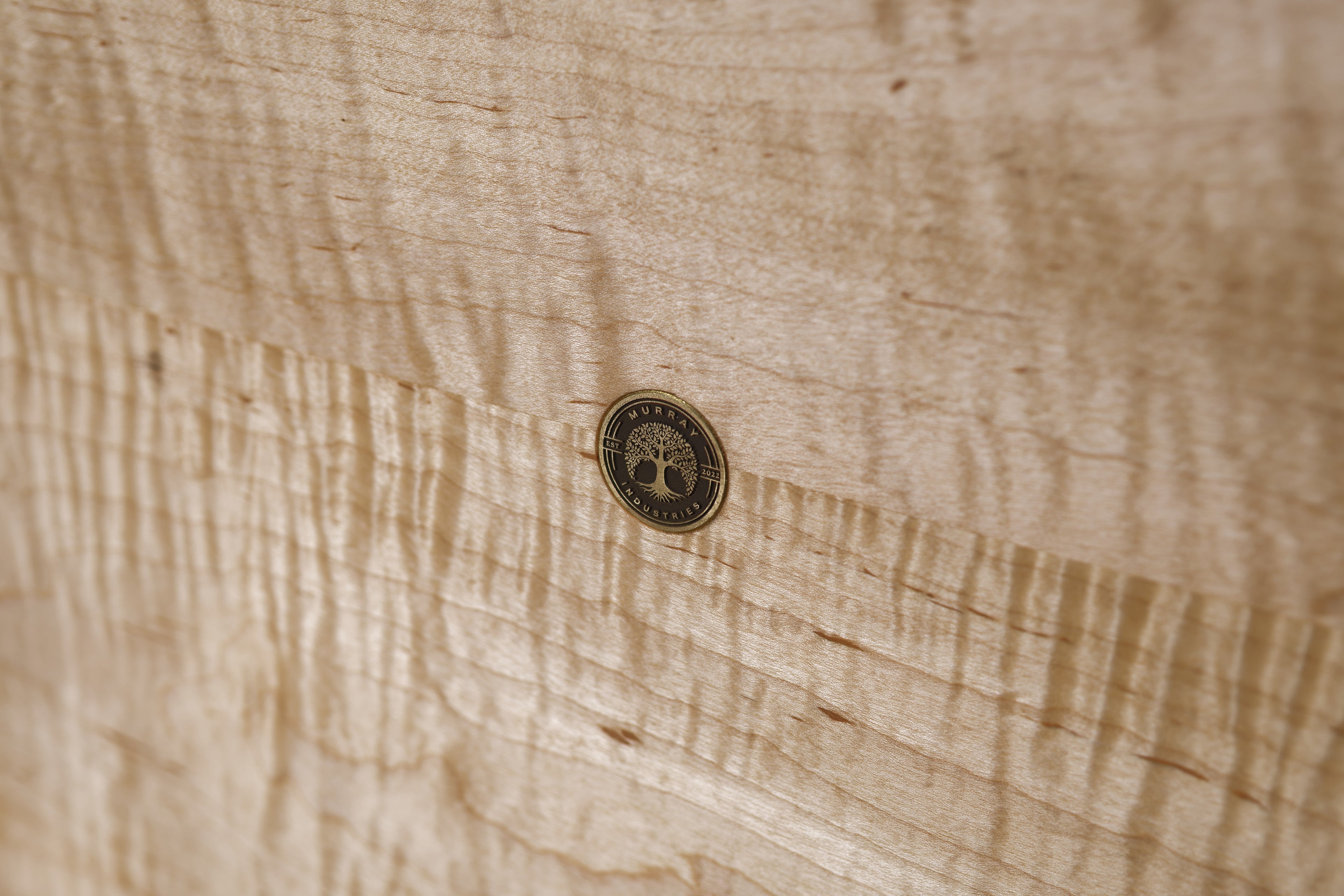 Murray Industries brand medallion on curly maple